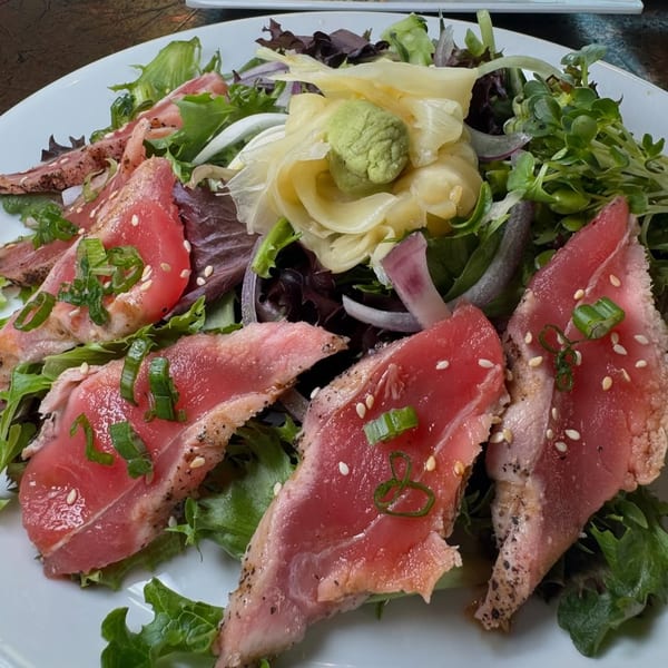 Seared tuna salad with mixed greens, red onion, pickled ginger, wasabi, and sesame seeds.